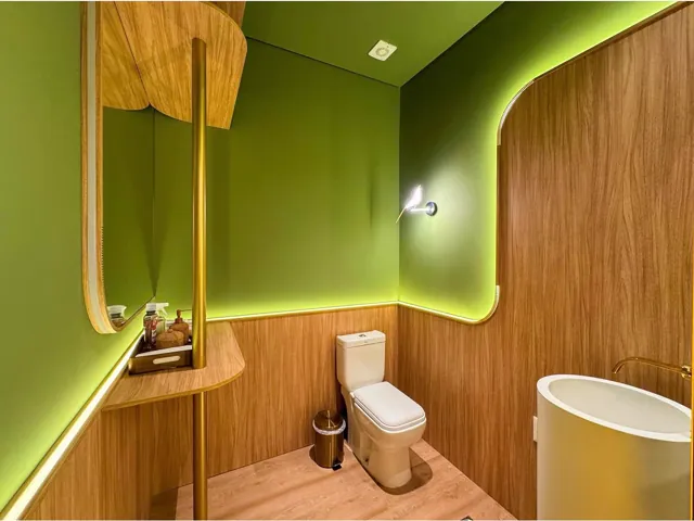 Lavabo em verde-oliva com painéis de madeira, cuba escultural e metais dourados